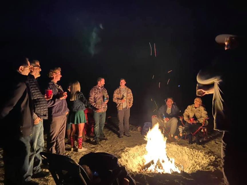 gathering around beach bonfire at night on atlantic beach