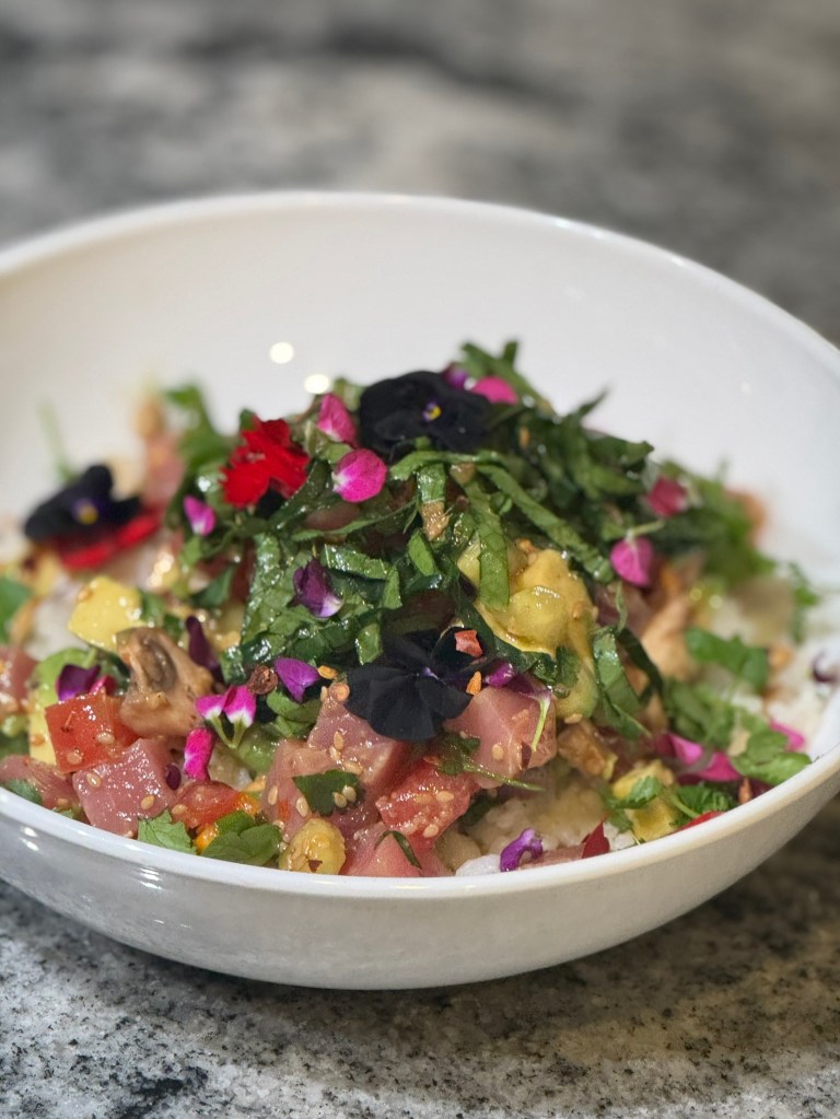tuna poke with Black Viola flowers and flower petals from pink and purple Hot Cakes Stock flowers in a white bowl
